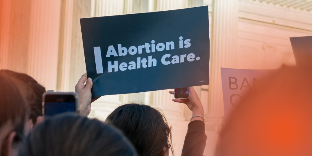 Stock image of person holding up a sign that says Abortion is Health Care